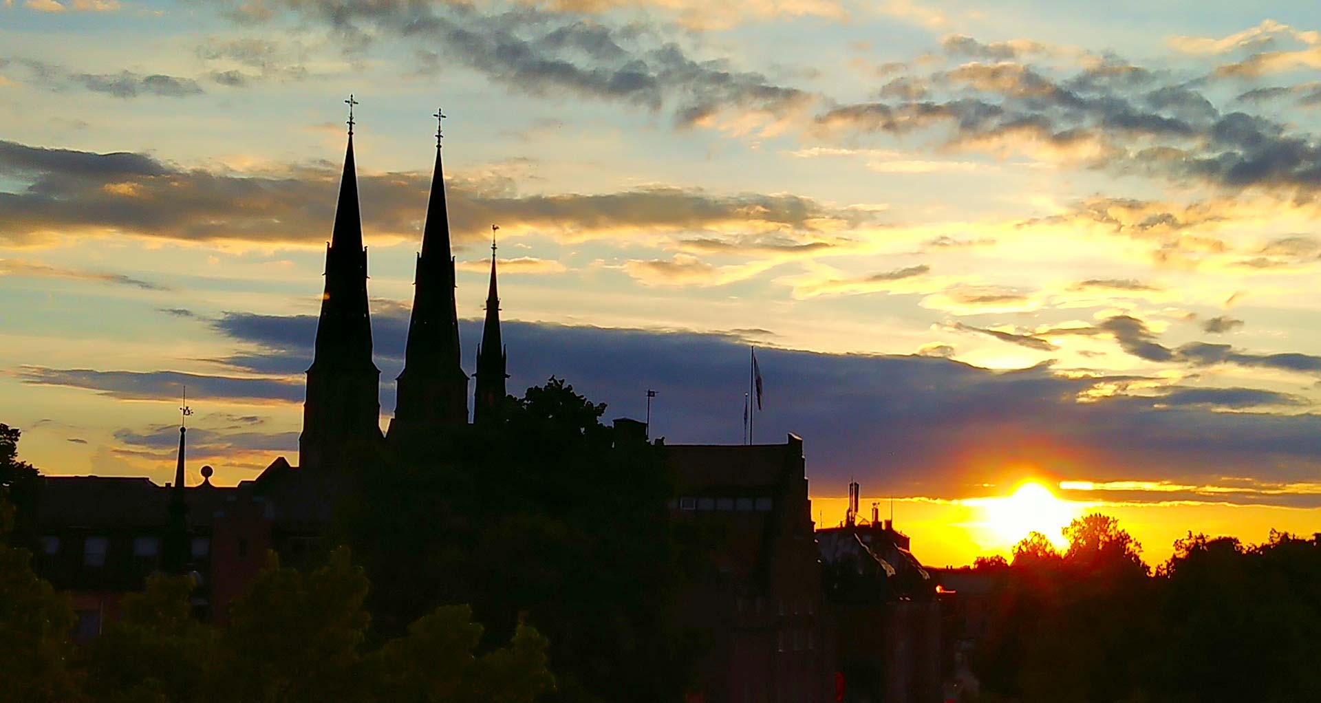 Uppsala domkyrka med en solnedgång i bakgrunden