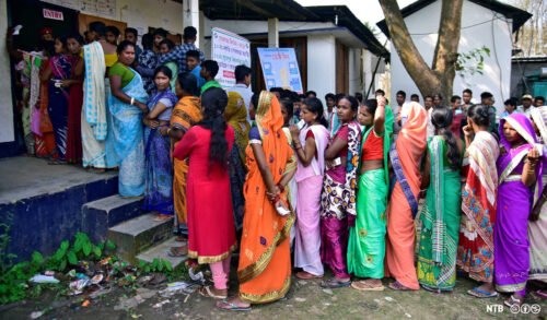 Väljare står i kö för att rösta i Indien