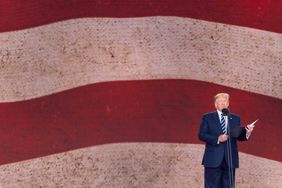 Donald Trump talar framför stor USA-flagga